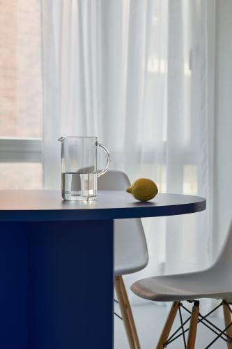 Interior design by Steffi Bühlmaier - Detailfoto: blauer Tisch und Eames Stuhl vor einem Fenster