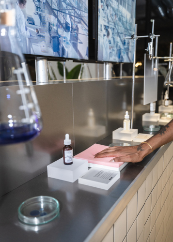 Steffi Bühlmaier Set Design. Skincare brand The Ordinary’s temporary showroom at the Highsnobiety 
Store in Berlin. Products are displayed in laboratory vessels on a tiled
 counter with steel tabletop.