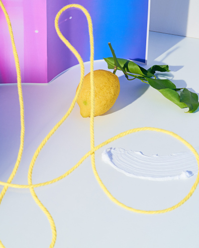 Steffi Bühlmaier Set Design. yellow thread and lemon with green leaves in front of gradient - set design: steffi bühlmaier steffibuehlmaier - photography: paul kusserow - freie sache - abstract art