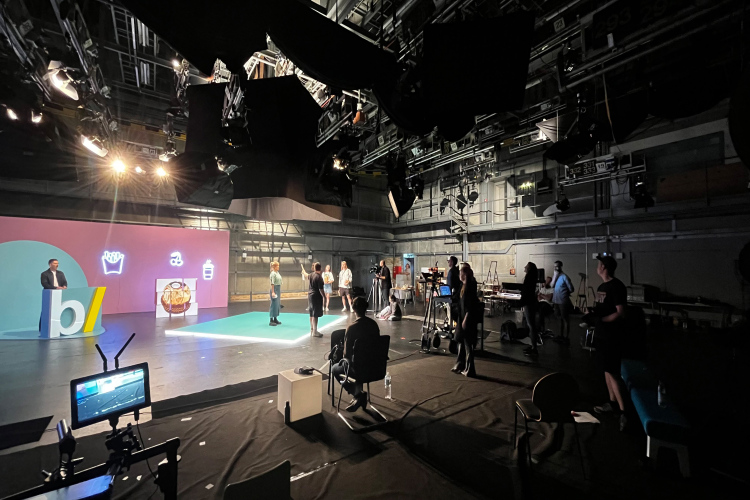 Steffi Bühlmaier Set Design. film crew at a TV show set in film studio with pink walls and a blue dot, food icons - besseresser - ZDF - - set design - steffi bühlmaier steffibuehlmaier
