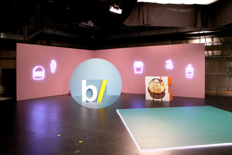 Steffi Bühlmaier Set Design. TV show set in film studio with pink walls and a blue dot, food icons - besseresser - ZDF - - set design - steffi bühlmaier steffibuehlmaier

